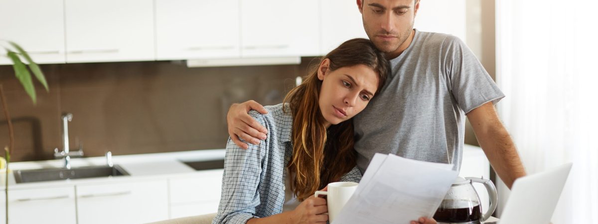 Negative human emotions. Financial problems. Portrait of unhappy young couple having looking worried while reading notification informing them about eviction from appartment because of unpaid bills