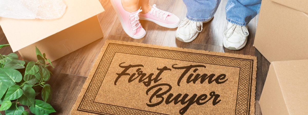 Man and Woman Unpacking Near Our First Time Buyer Welcome Mat, Moving Boxes and Plant.